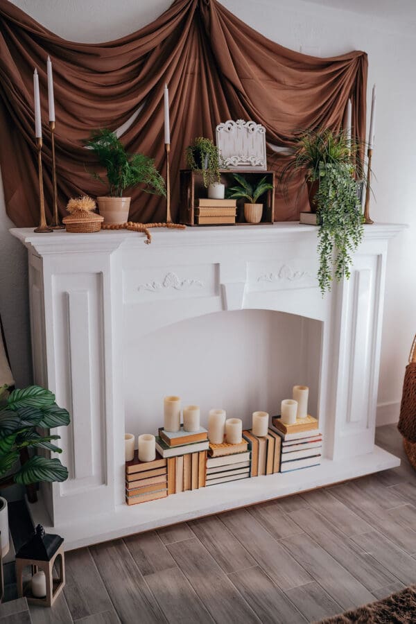 A fireplace with candles and plants on the mantle.