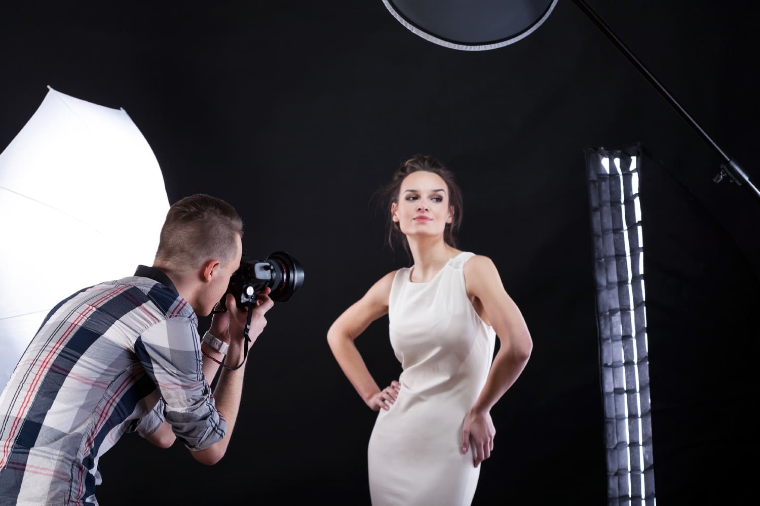 A man taking a picture of a woman in a dress.