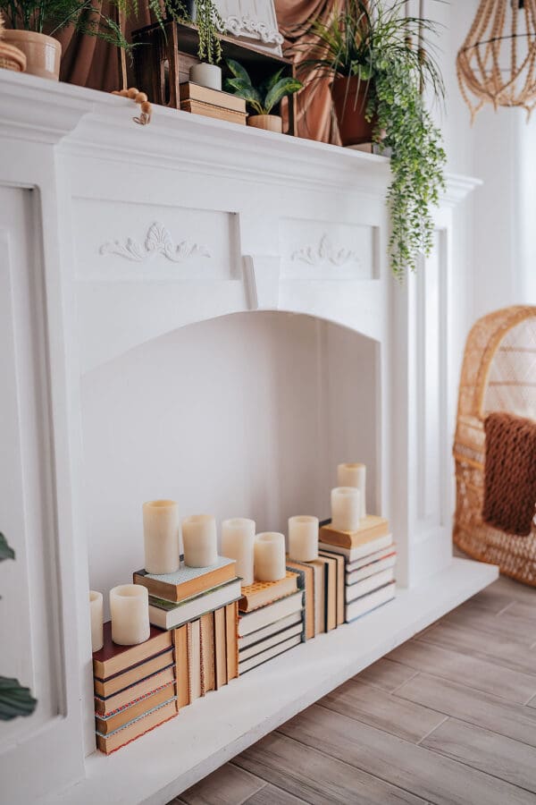 A fireplace with books and candles on it