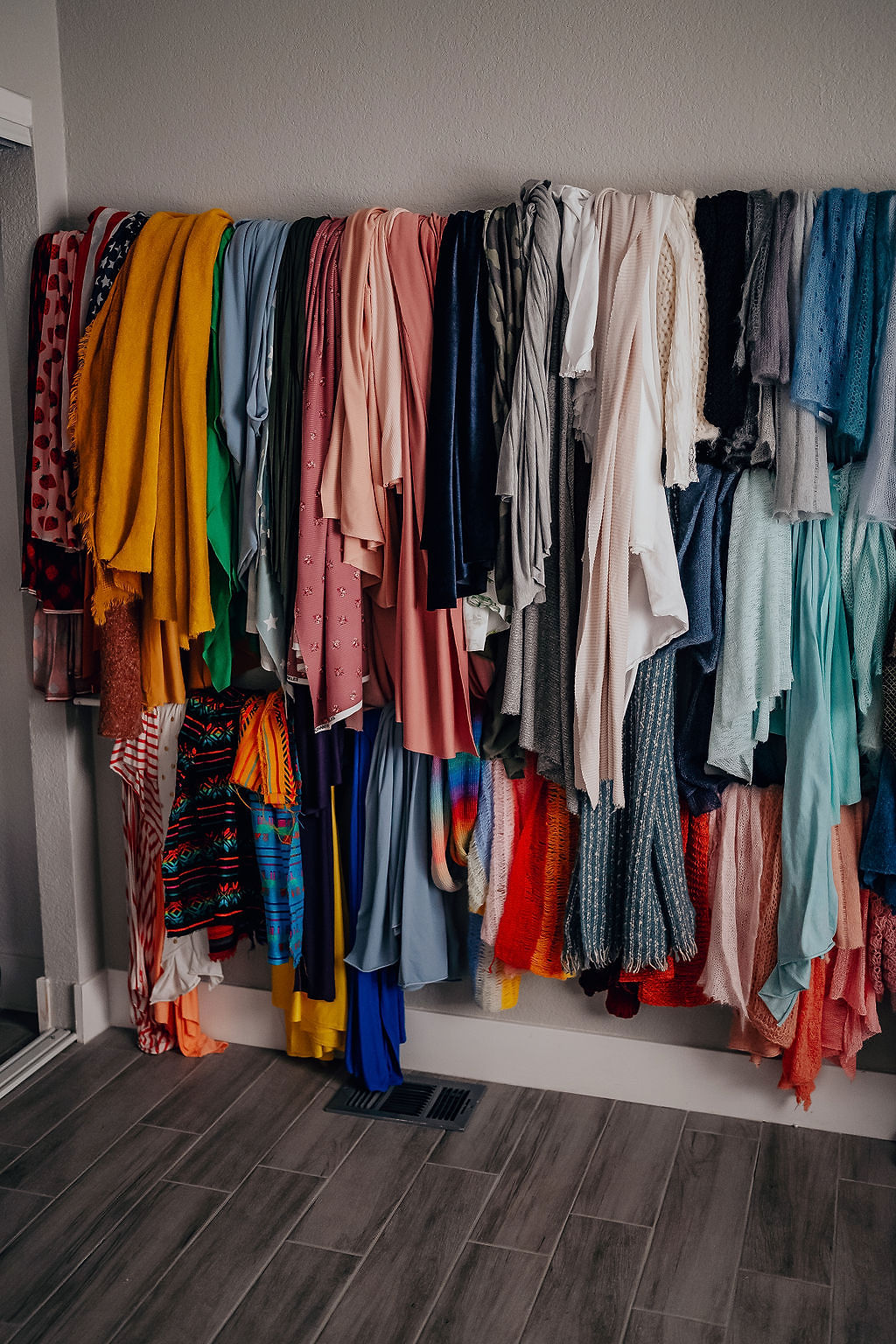 A closet full of different colored shirts hanging.