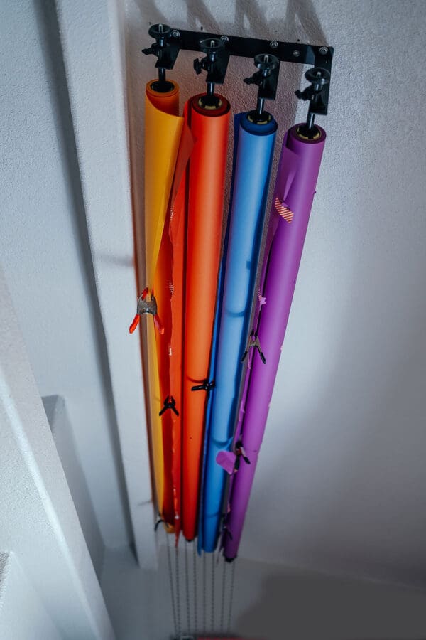 A bunch of different colored umbrellas hanging from the ceiling.