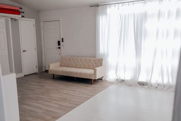 A living room with white walls and wooden floors.