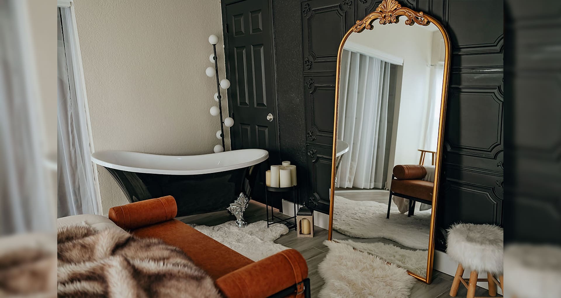 A room with a tub, mirror and couch.