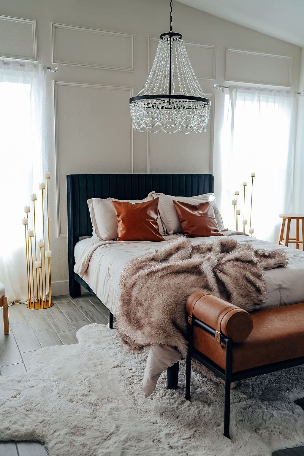 A bedroom with a bed, chair and window.