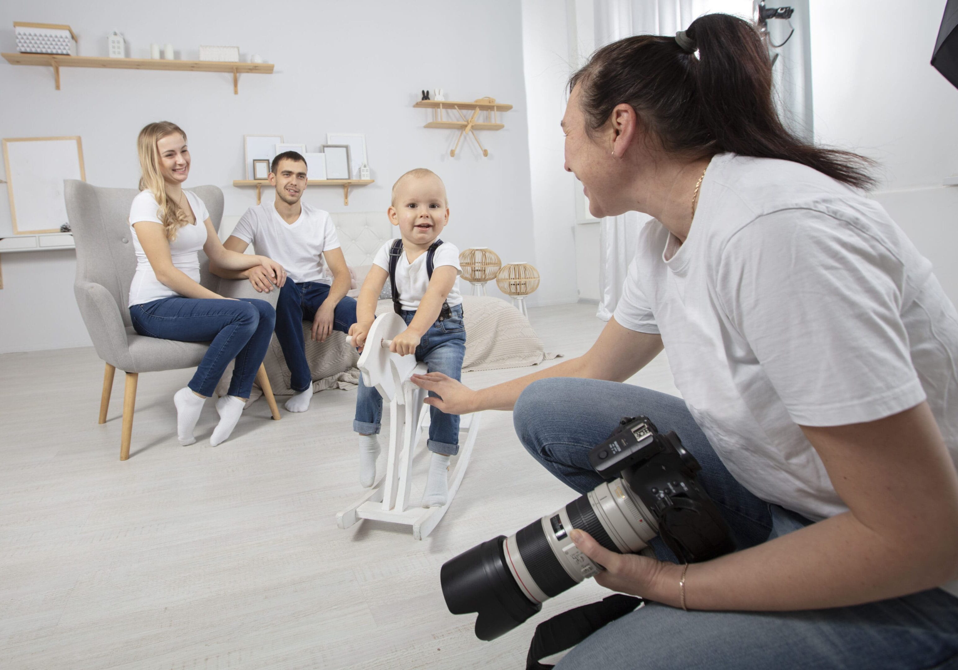 A photographer photographs a family in a photo studio. J&M Studios